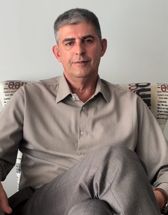 Dr Waldenez Garcia de social sentado em sua poltrona estampada de jornal e pousando para a foto